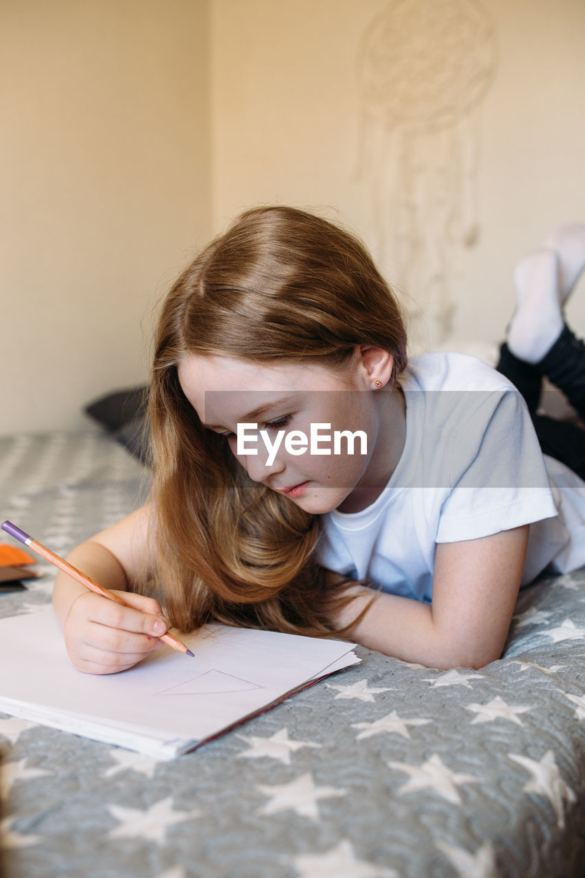 close-up of girl drawing on paper at home