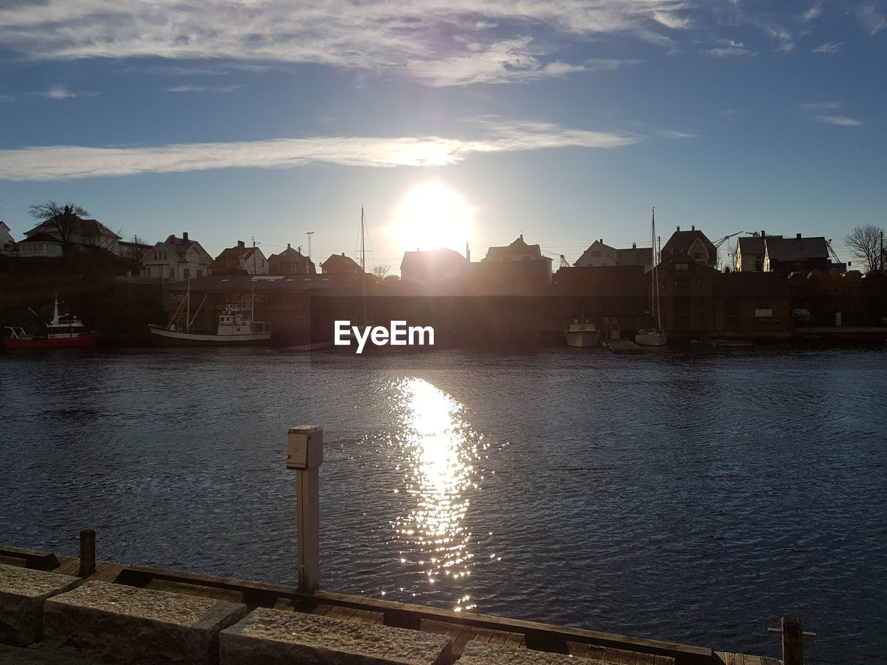 BUILDINGS BY RIVER AGAINST SKY