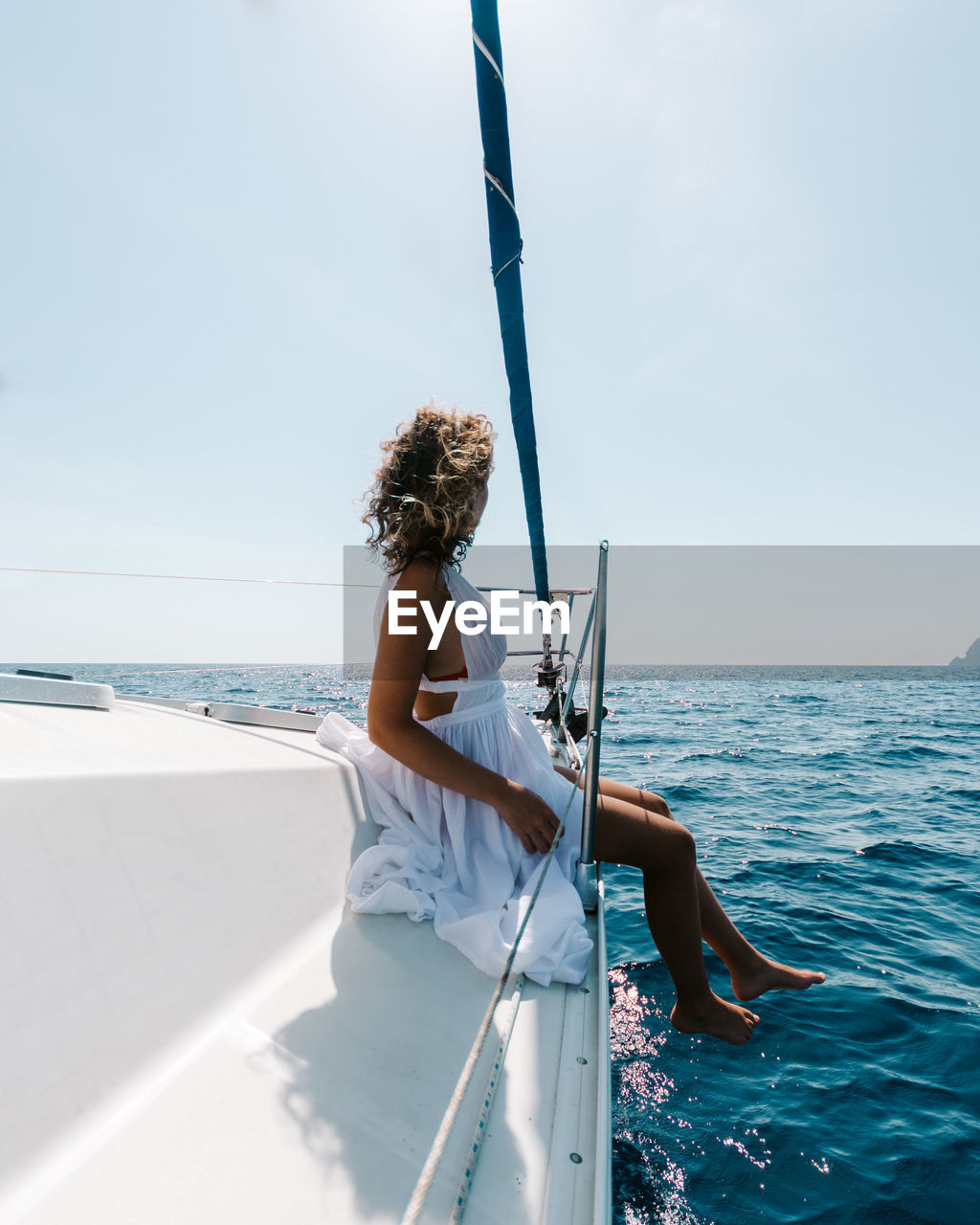 Full length of woman sitting on boat deck in sea