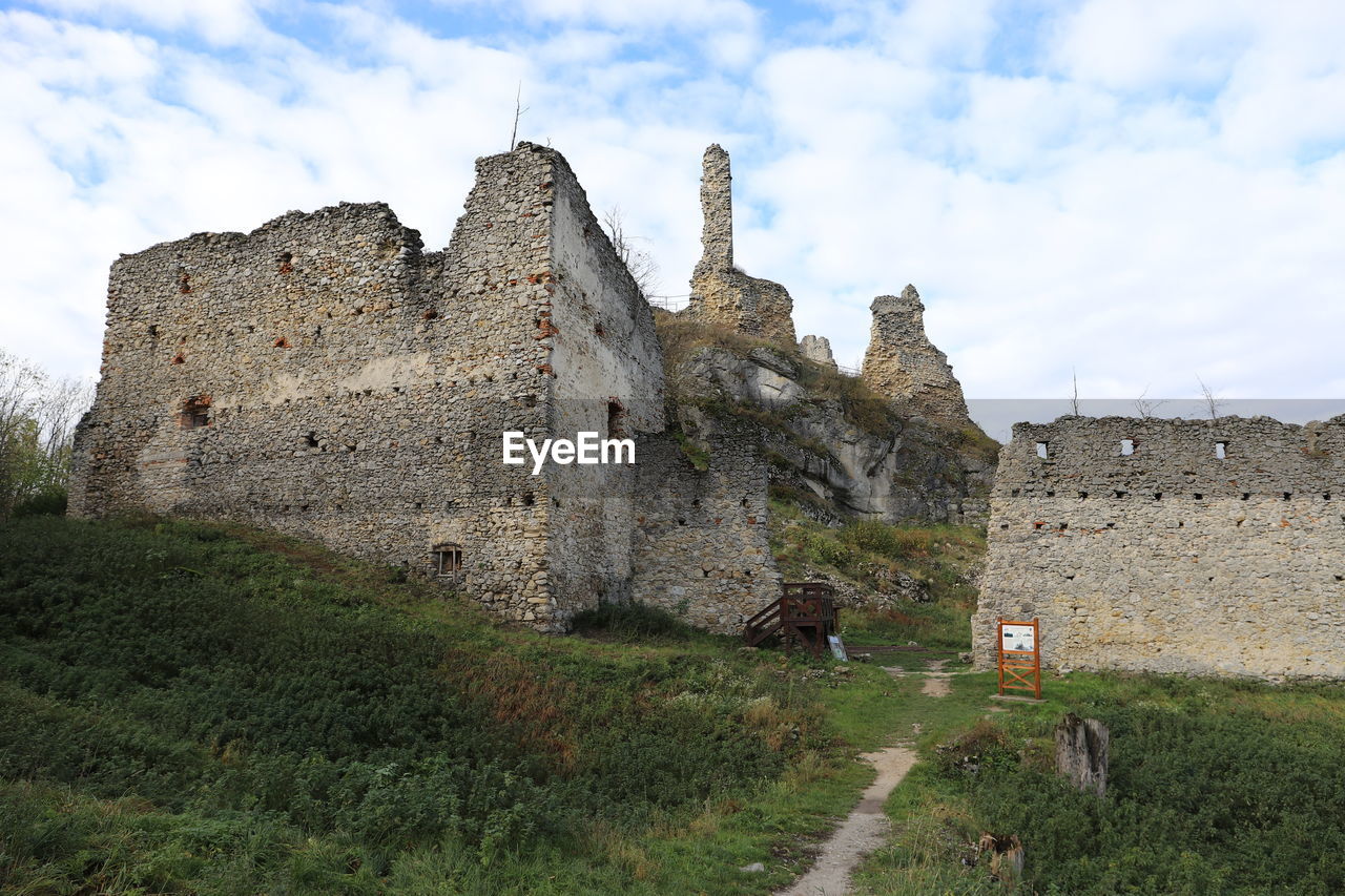 architecture, history, castle, the past, built structure, sky, building, fortification, ruins, building exterior, château, travel destinations, cloud, nature, travel, ancient, old, fort, wall, plant, tourism, old ruin, historic site, grass, medieval, land, day, outdoors, stone material, no people, ancient history, fortified wall, village, wall - building feature, landscape, stone wall, moat, rural area, ruined, tree