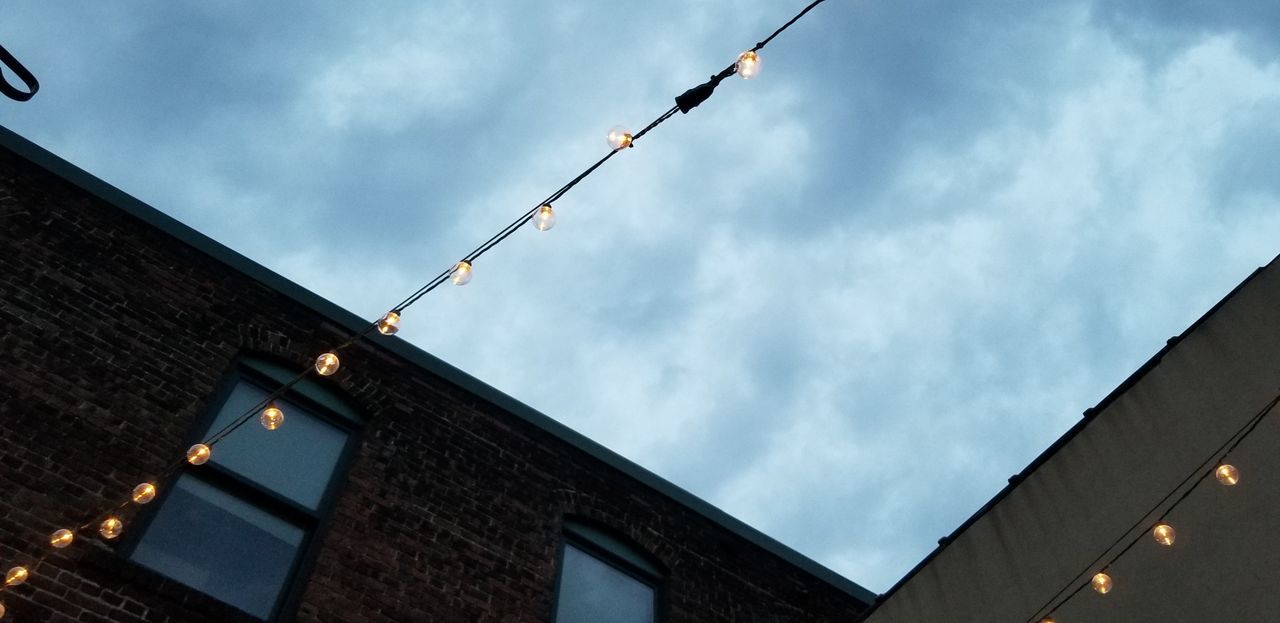 LOW ANGLE VIEW OF ILLUMINATED STREET LIGHT AGAINST BUILDINGS