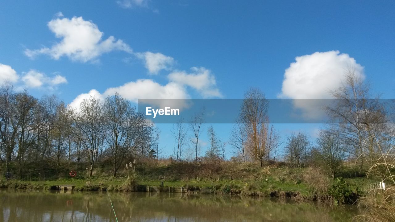 SCENIC VIEW OF CALM LAKE AGAINST CLOUDY SKY