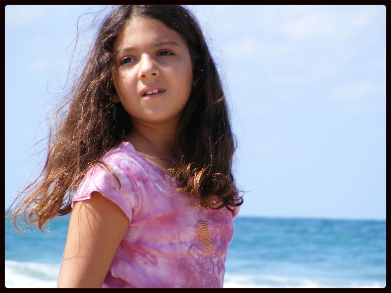 Close-up of a cute girl standing at beach