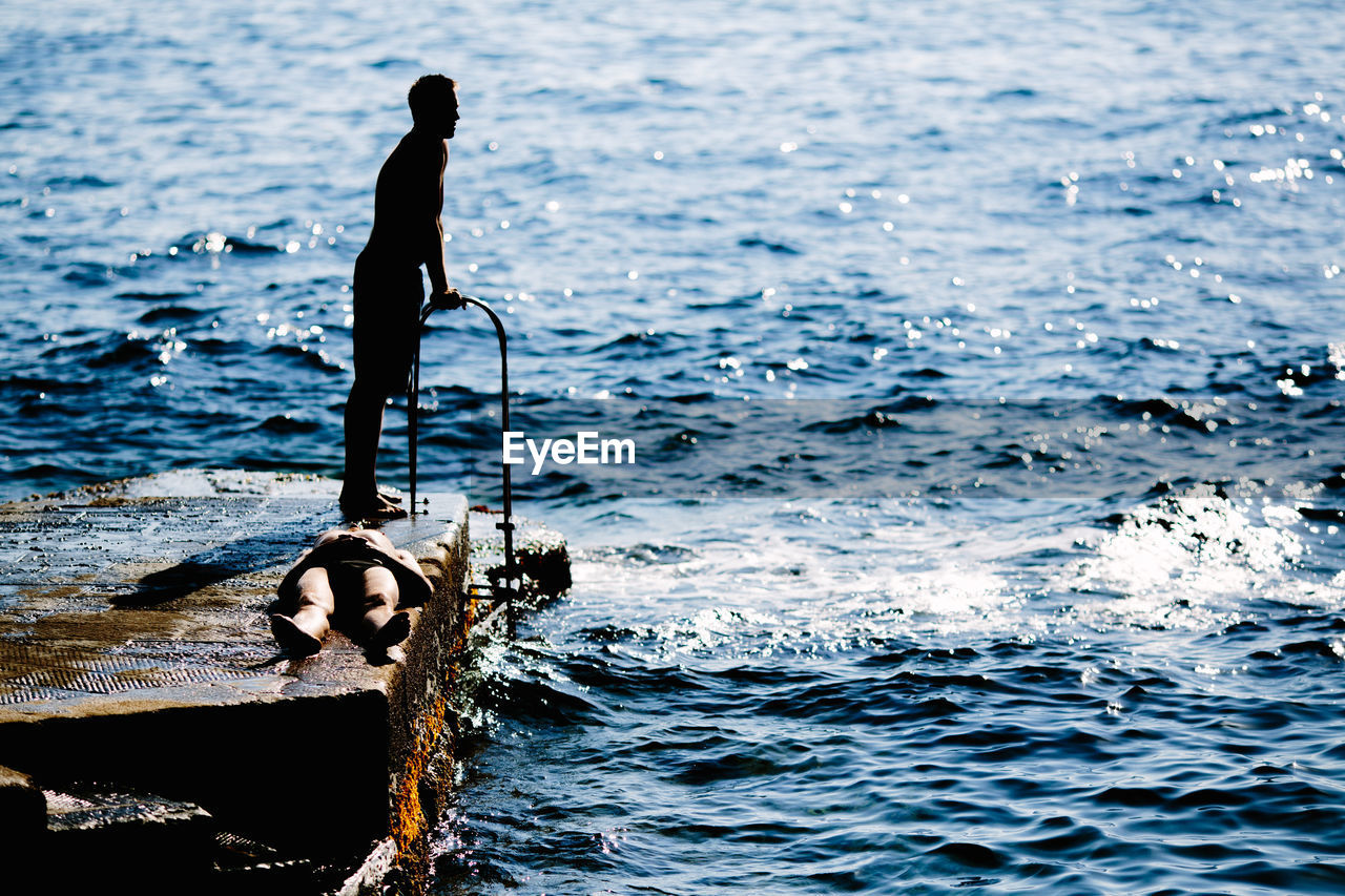 SILHOUETTE OF MAN IN SEA