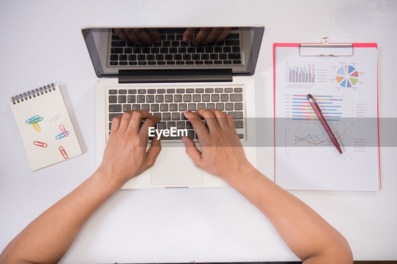 LOW ANGLE VIEW OF PERSON USING LAPTOP