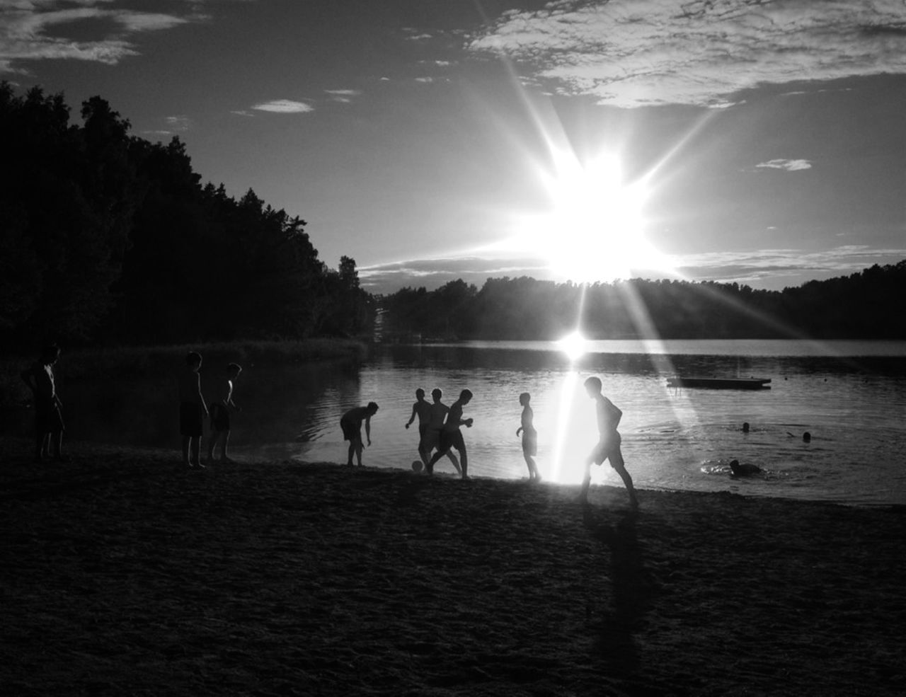 Group of silhouette people playing on beach