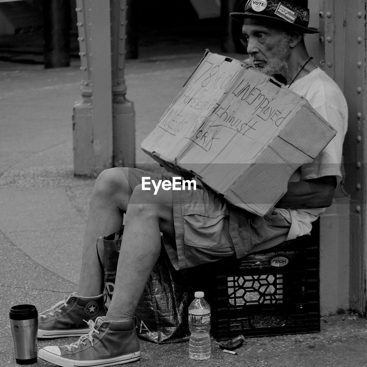 REAR VIEW OF MAN SITTING ON PAPER WITH CITY