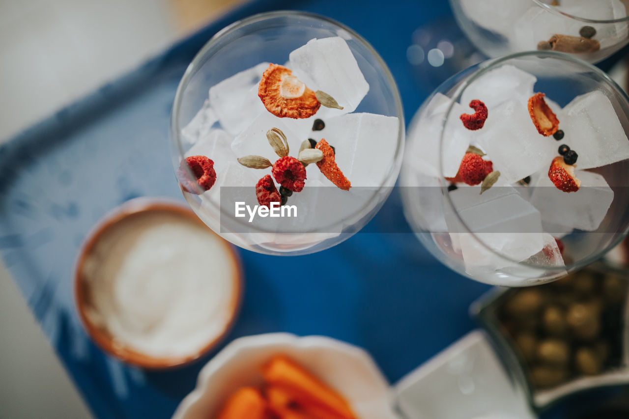 Directly above shot of ice cubes in wineglasses on table