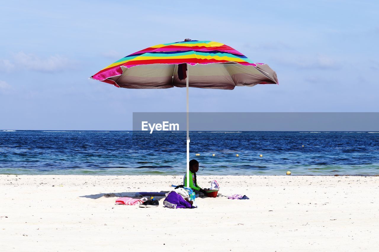 UMBRELLA ON BEACH AGAINST SKY