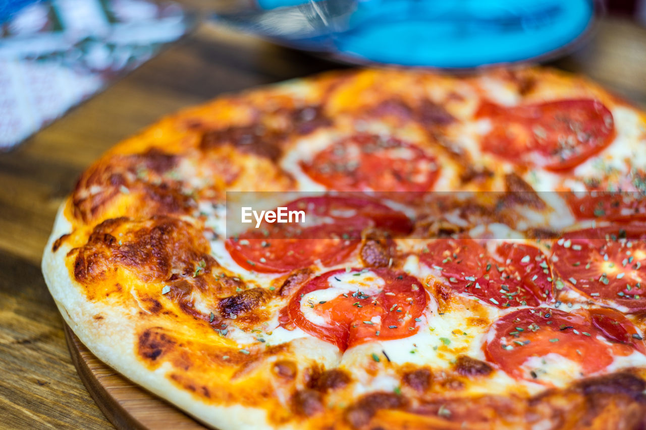 HIGH ANGLE VIEW OF PIZZA IN PLATE ON TABLE