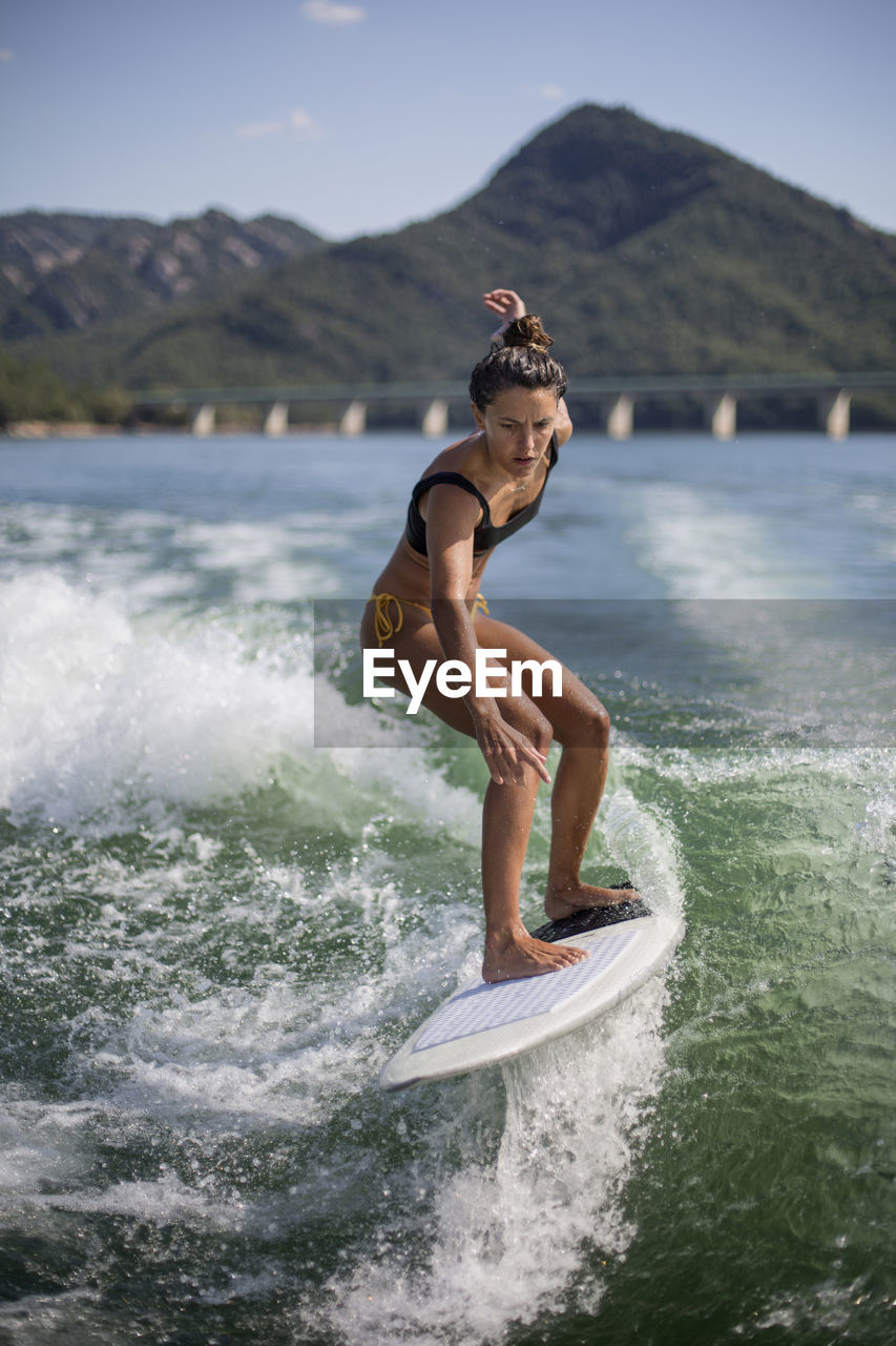 SIDE VIEW OF SHIRTLESS MAN IN SEA