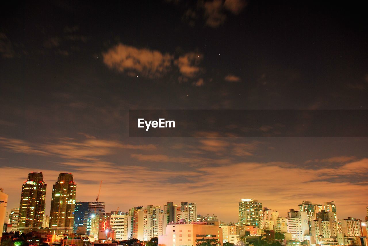 View of cityscape against cloudy sky