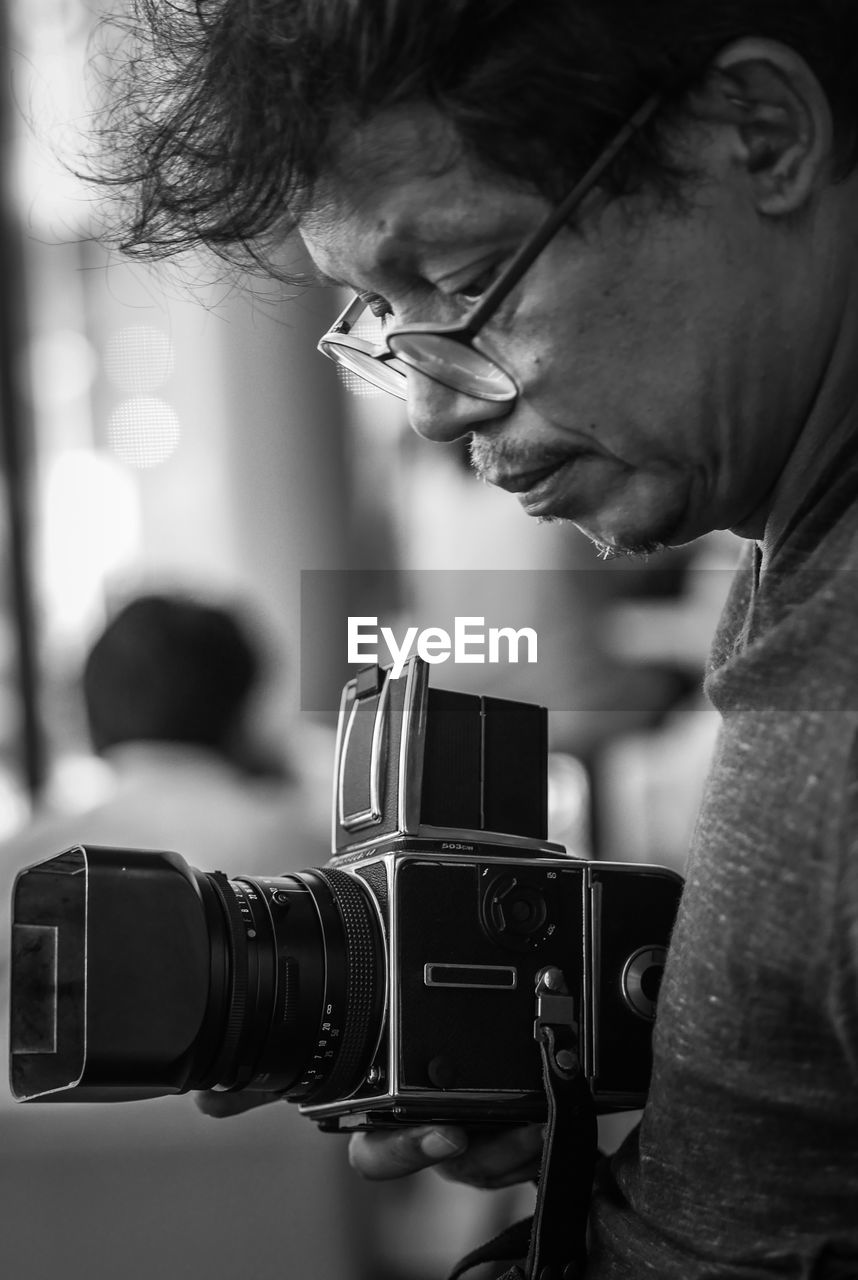 Close-up of man photographing with camera