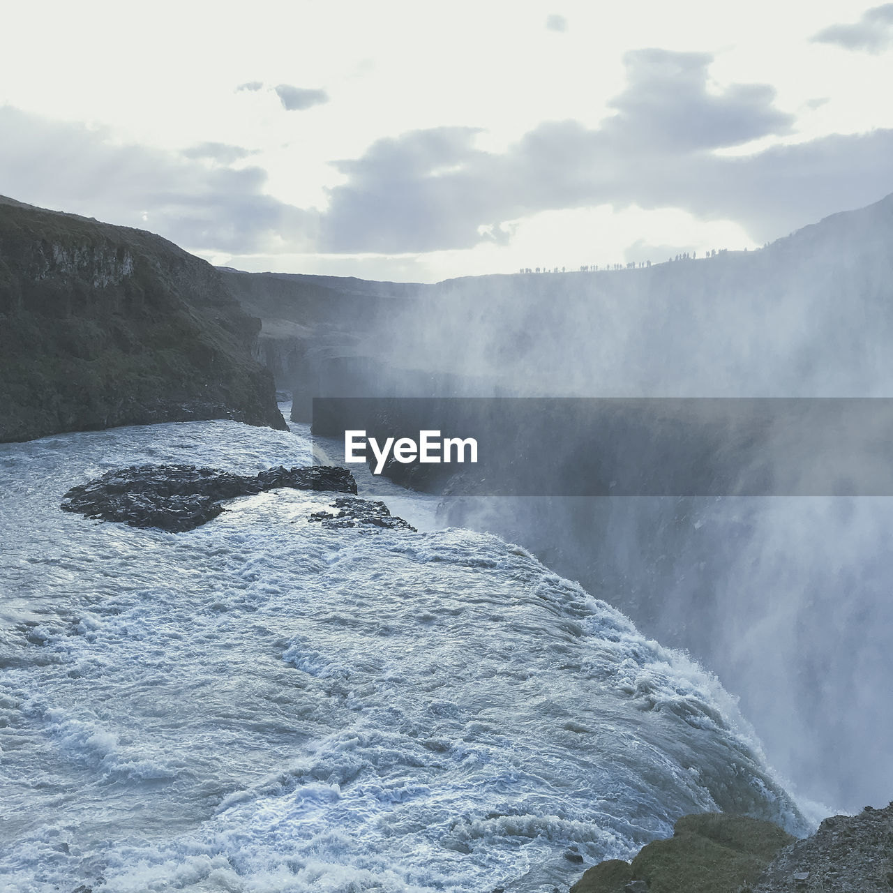 Scenic view of waterfall against sky