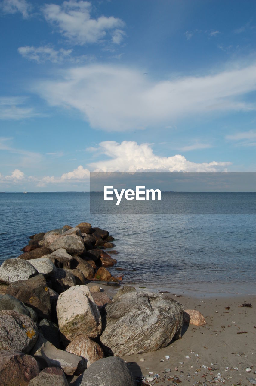 Rocks at beach against sky