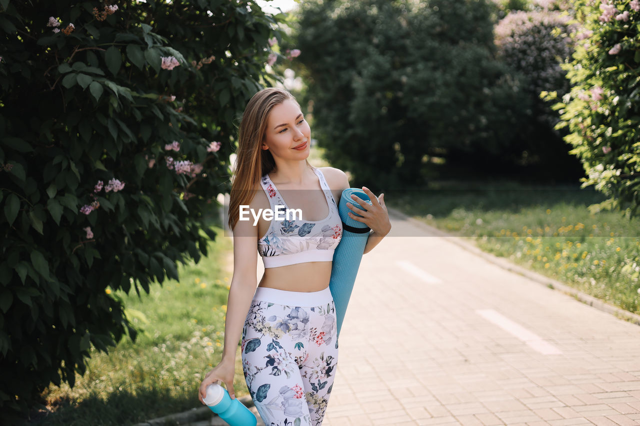 Athletic happy healthy young woman in sportswear goes after a sports workout exercise in nature