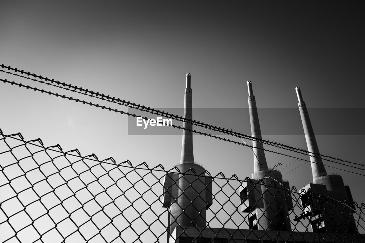 Low angle view of smoke stacks against sky