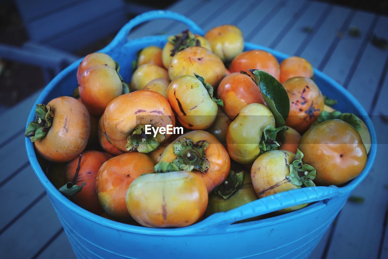 High angle view of persimmons in basket on table