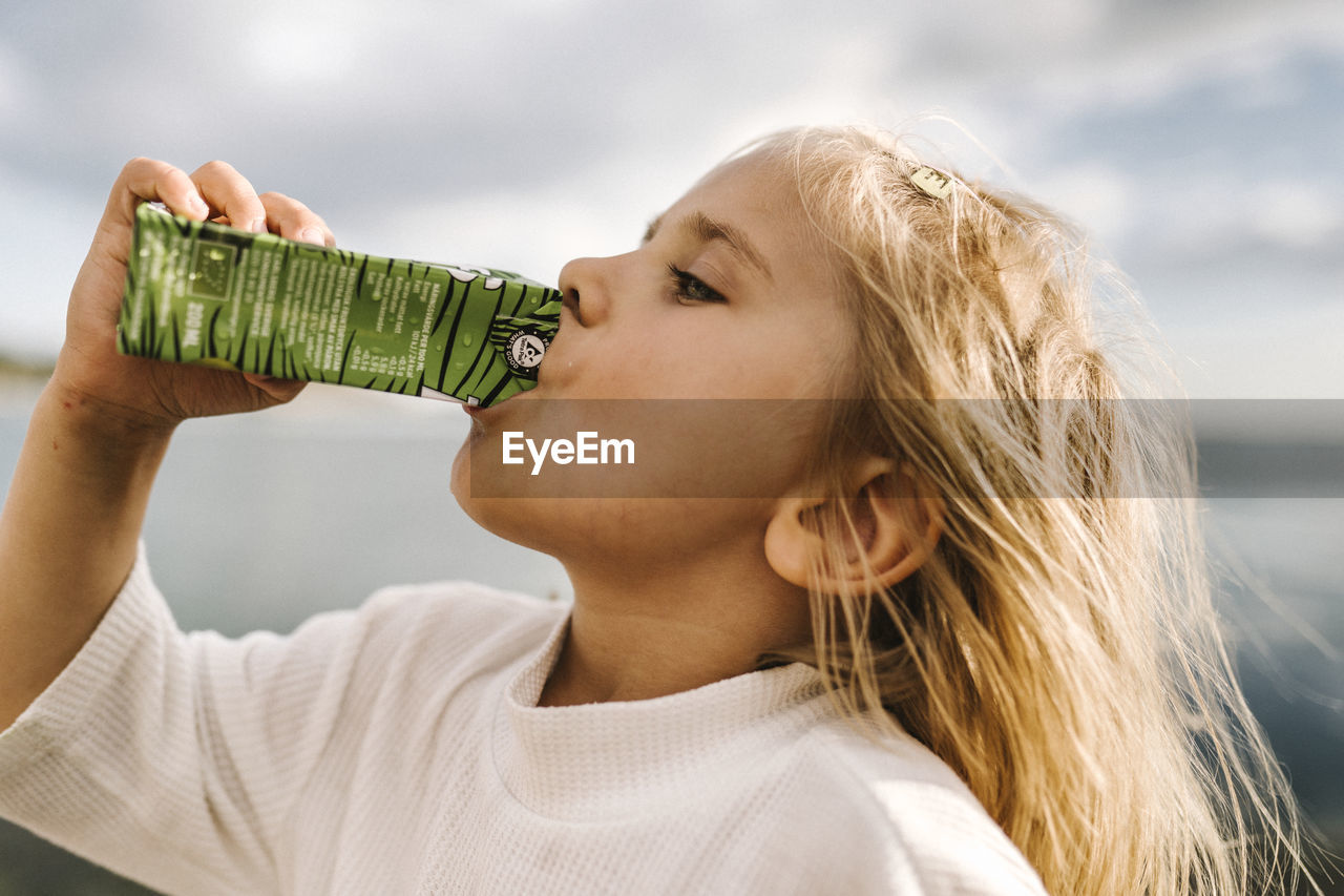 Side view of girl drinking from