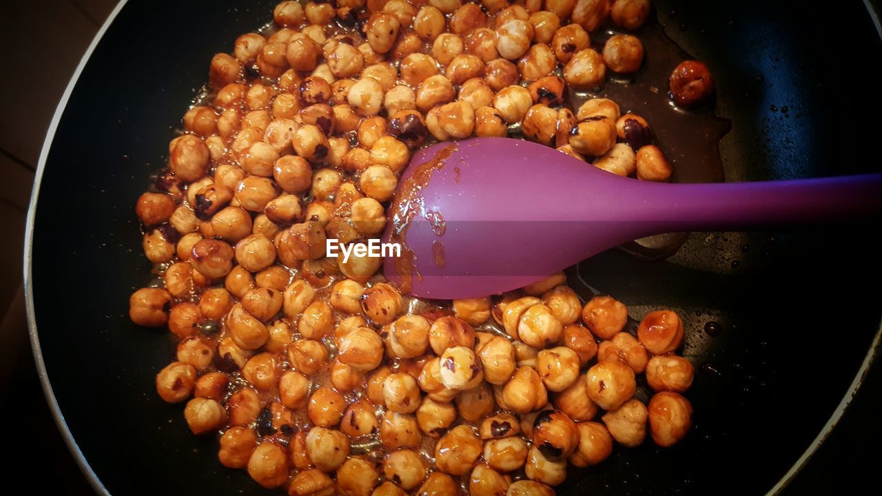 Close-up of hazelnuts cooking on frying pan at home