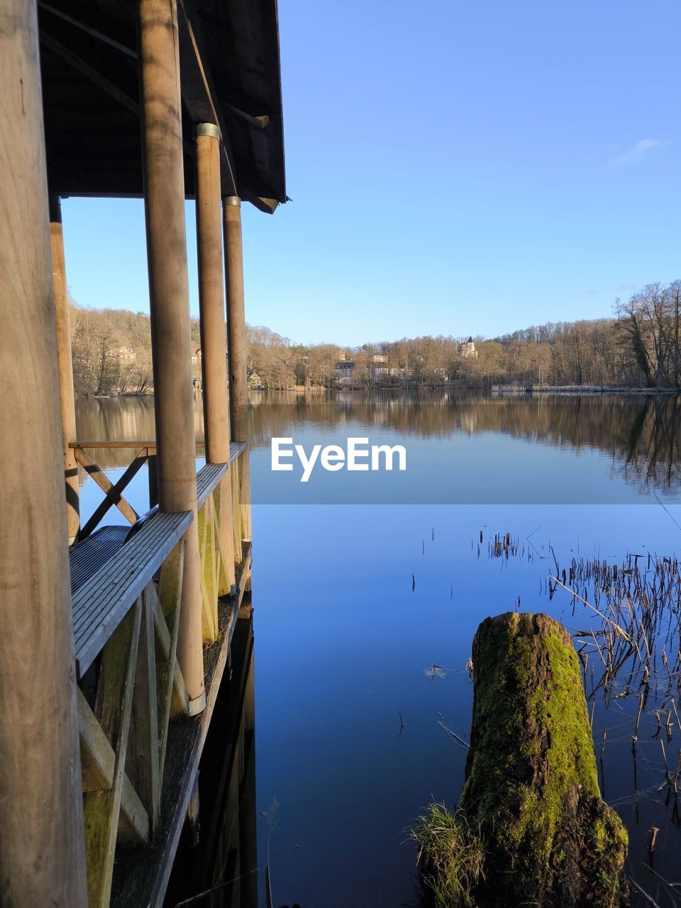 reflection, water, lake, sky, nature, tranquility, scenics - nature, no people, tranquil scene, blue, clear sky, beauty in nature, day, architecture, tree, plant, environment, landscape, body of water, built structure, outdoors, morning, wood, non-urban scene, reservoir, travel destinations, land, travel