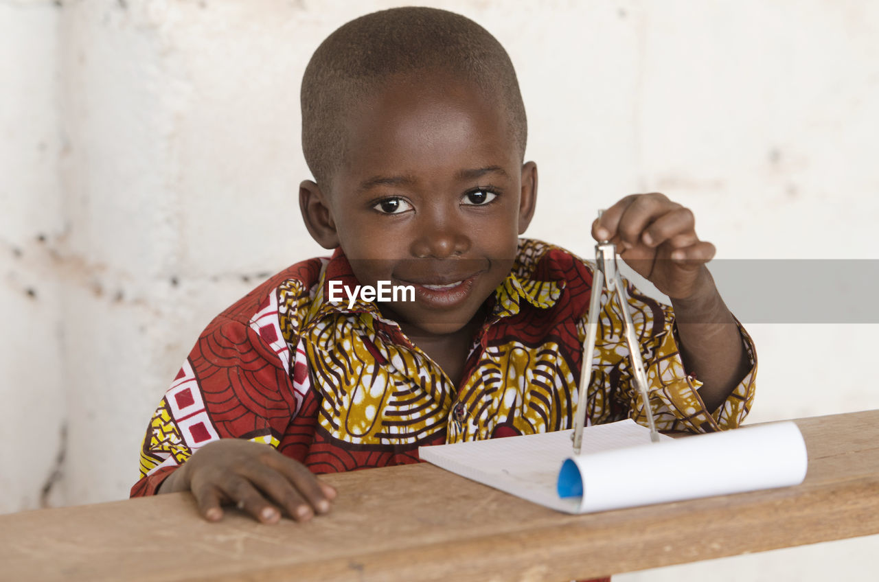 Portrait of cute boy studying in classroom