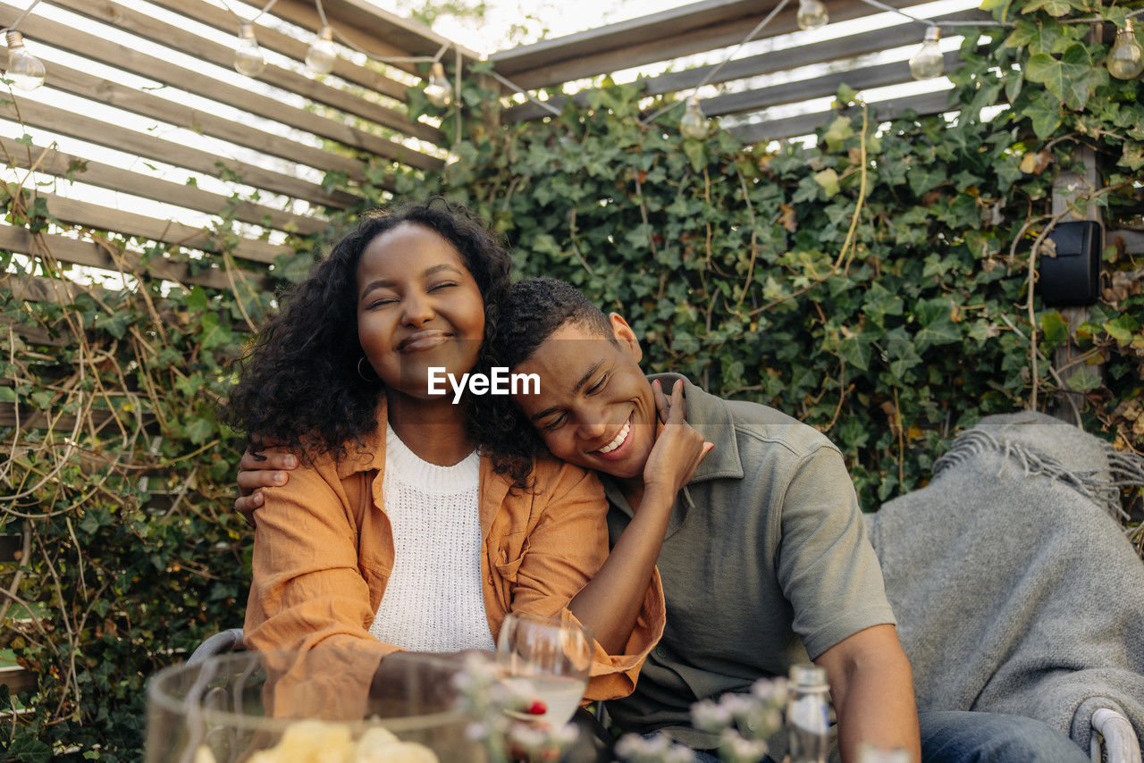 Smiling young man embracing female friend during party