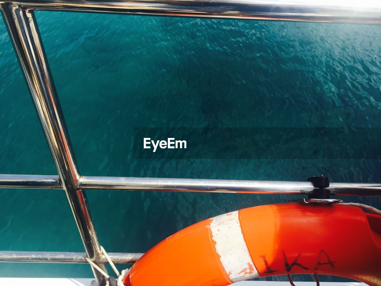 Life belt on railing of boat against sea