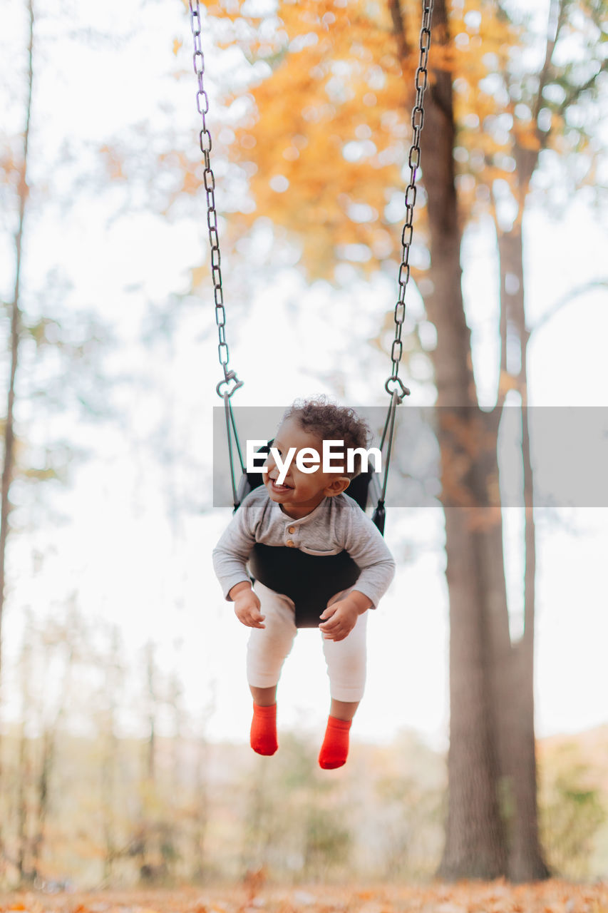 Full length of boy on swing at playground