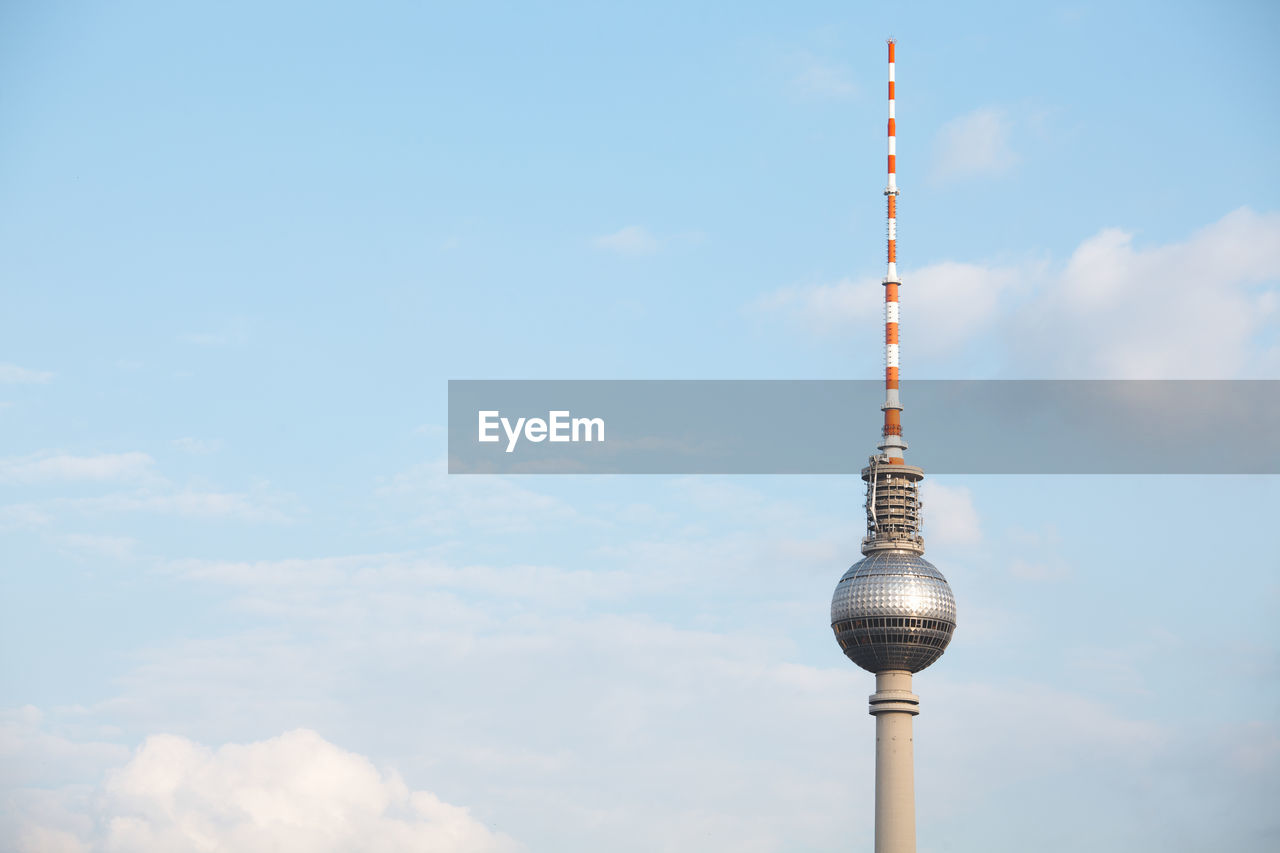 Low angle view of fernsehturm against cloudy sky