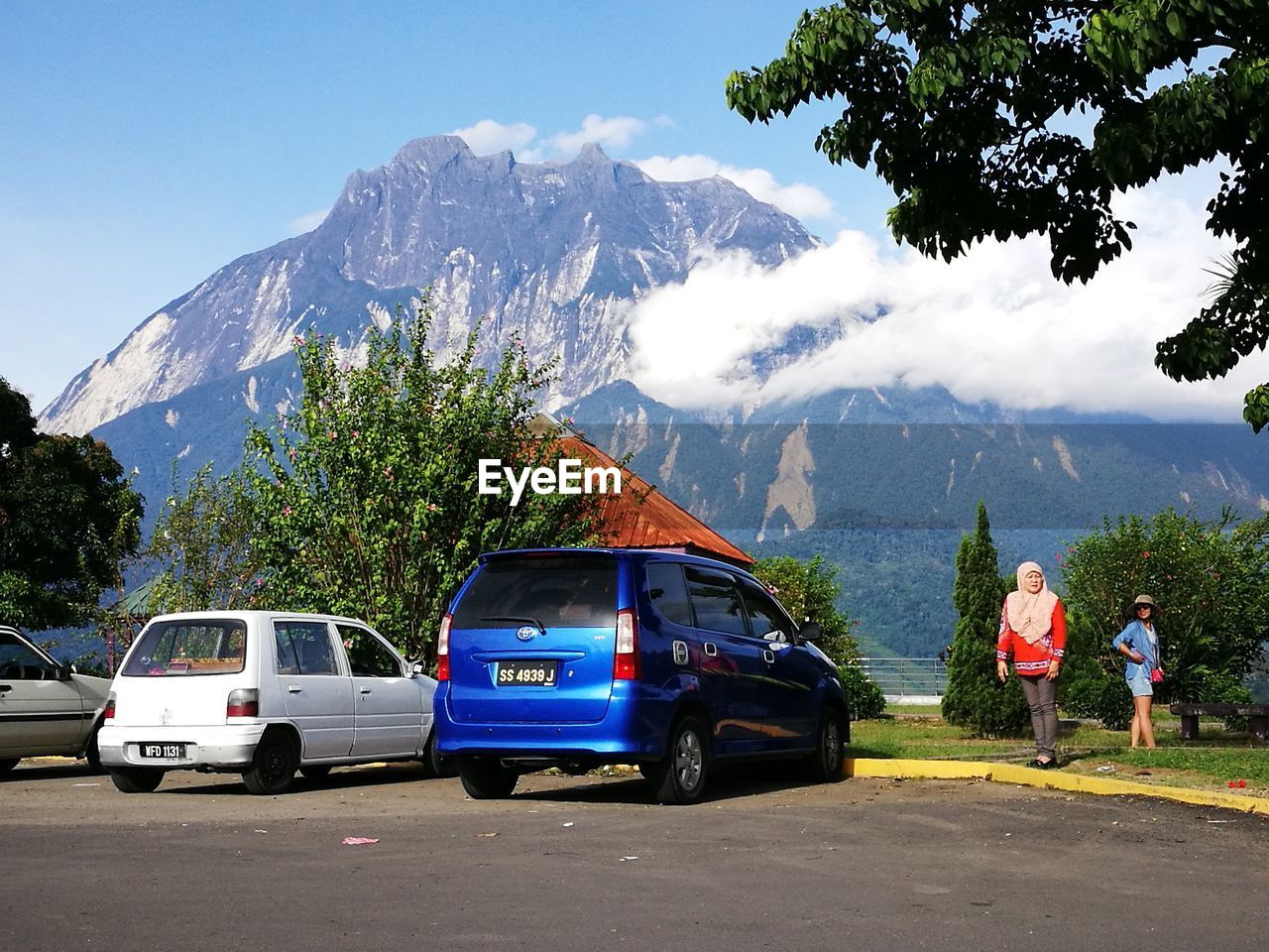 Women standing by parked cars against mountain