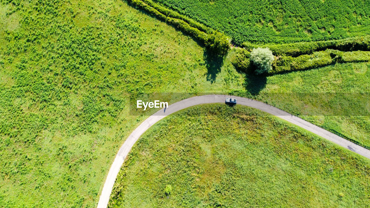 Aerial view of a countryside road between meadows and trees in emilia romagna region, italy