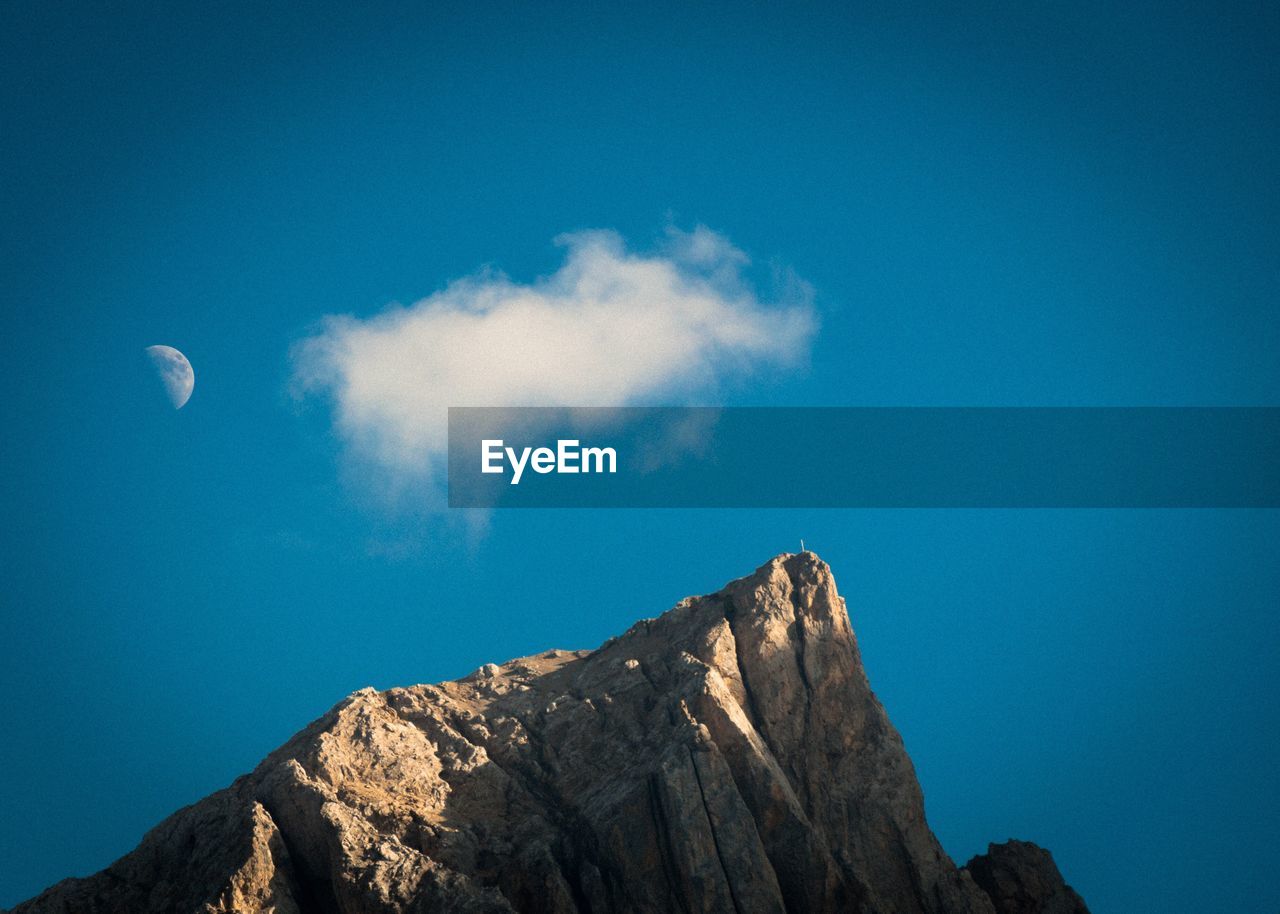 Low angle view of mountain against clear blue sky