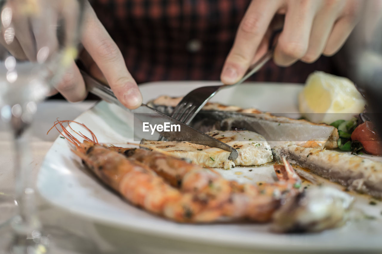 Close-up of hand having food at table