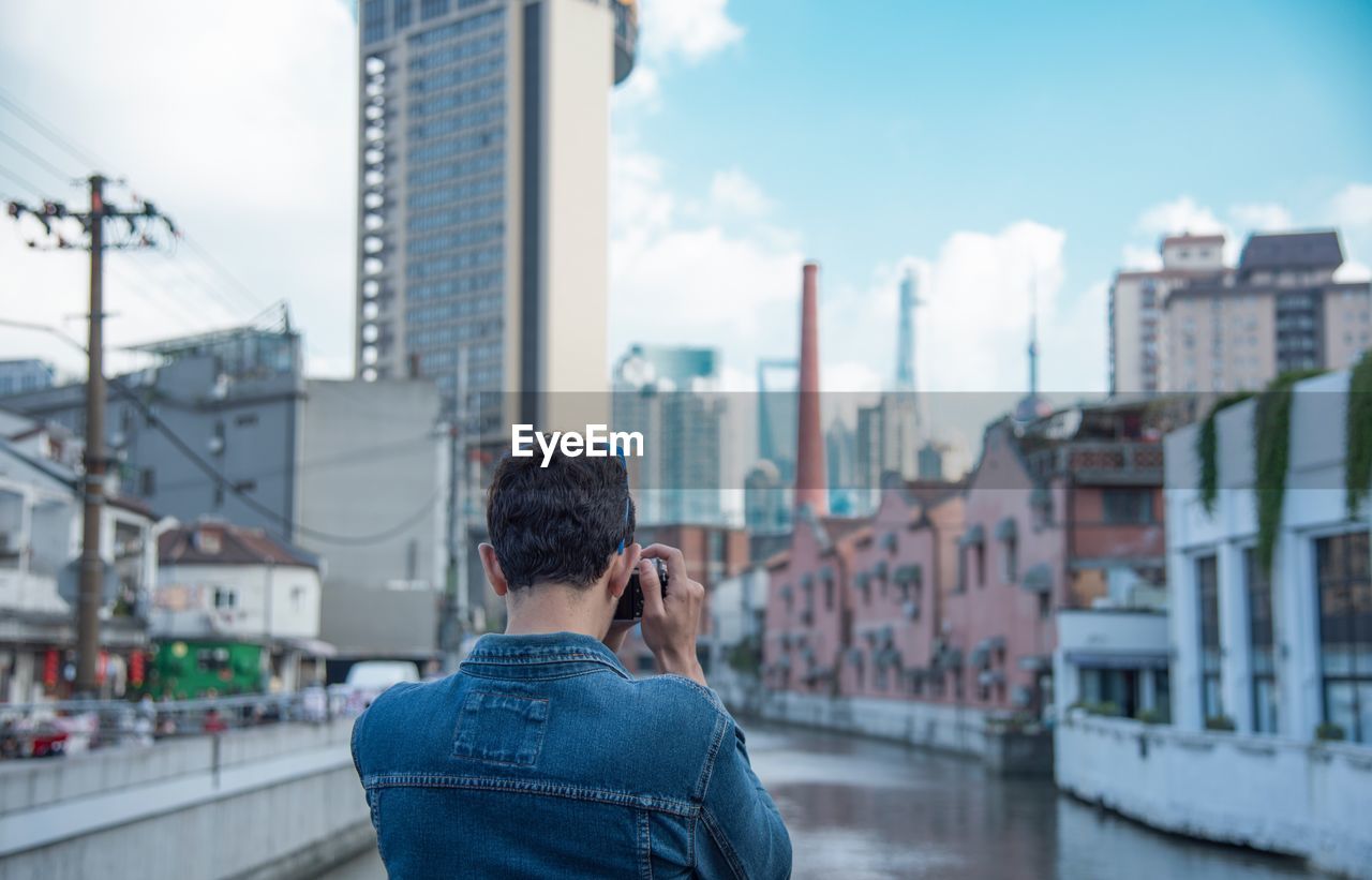 Rear view of man photographing cityscape