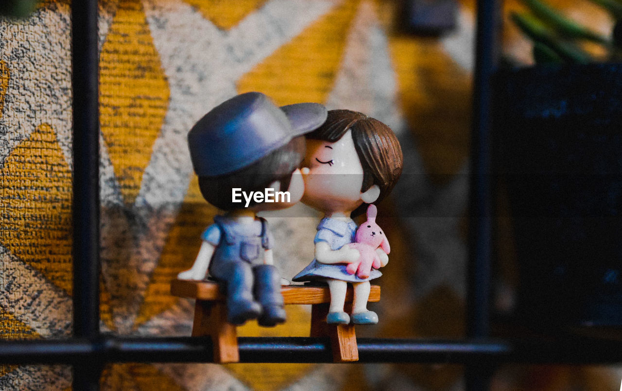 Kissing toy sitting on wooden bench