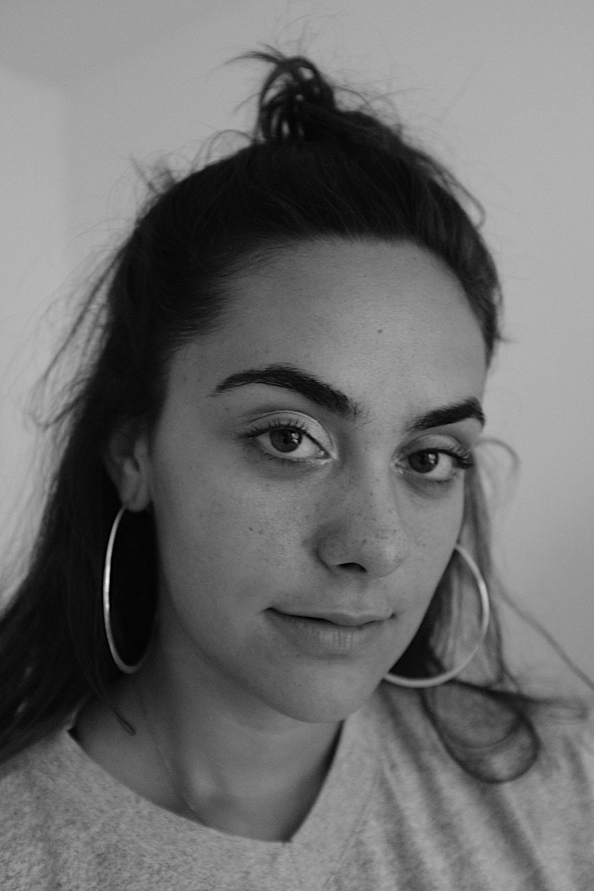 Close-up portrait of young woman against wall