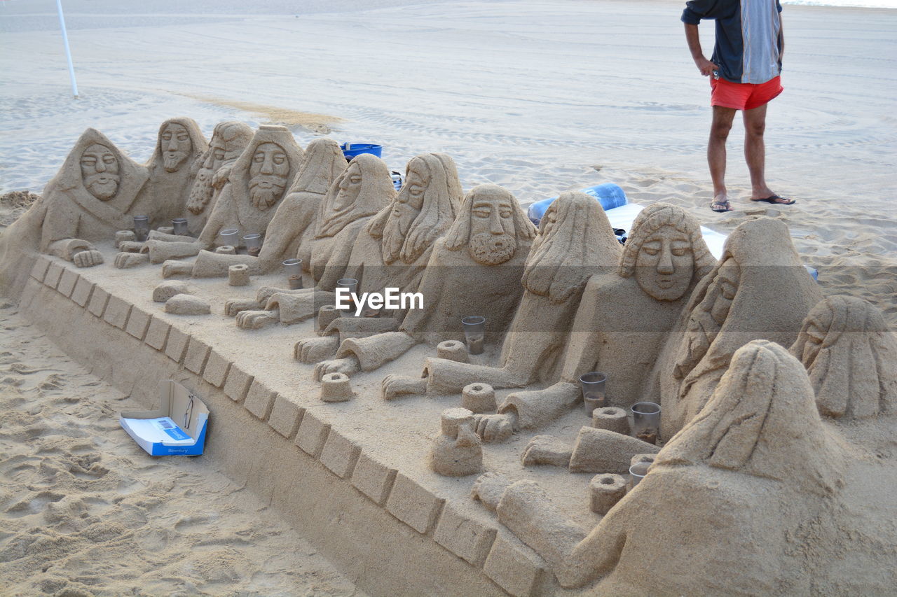 LOW SECTION OF MAN STANDING ON SAND