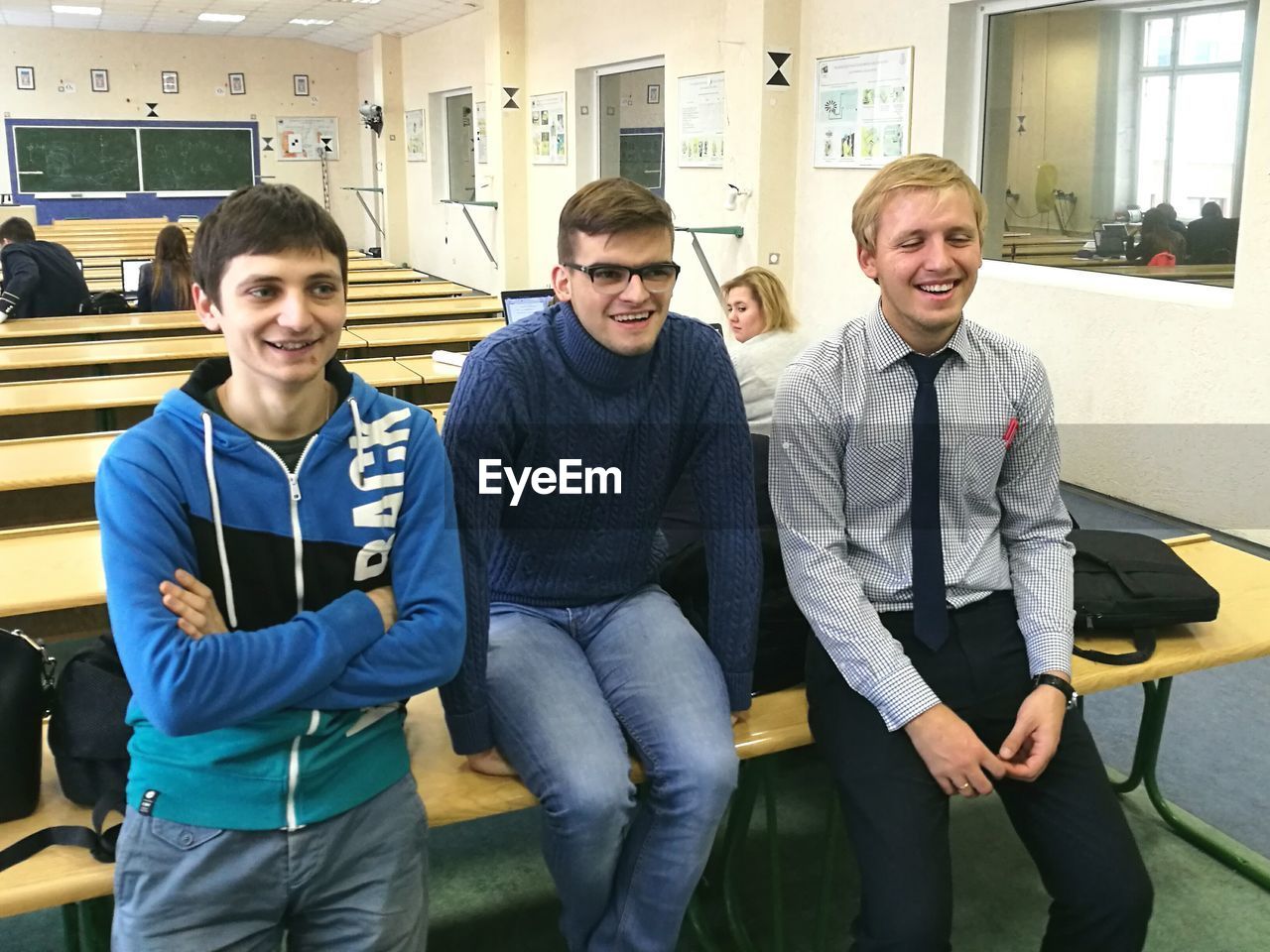 PORTRAIT OF SMILING YOUNG MEN IN OFFICE