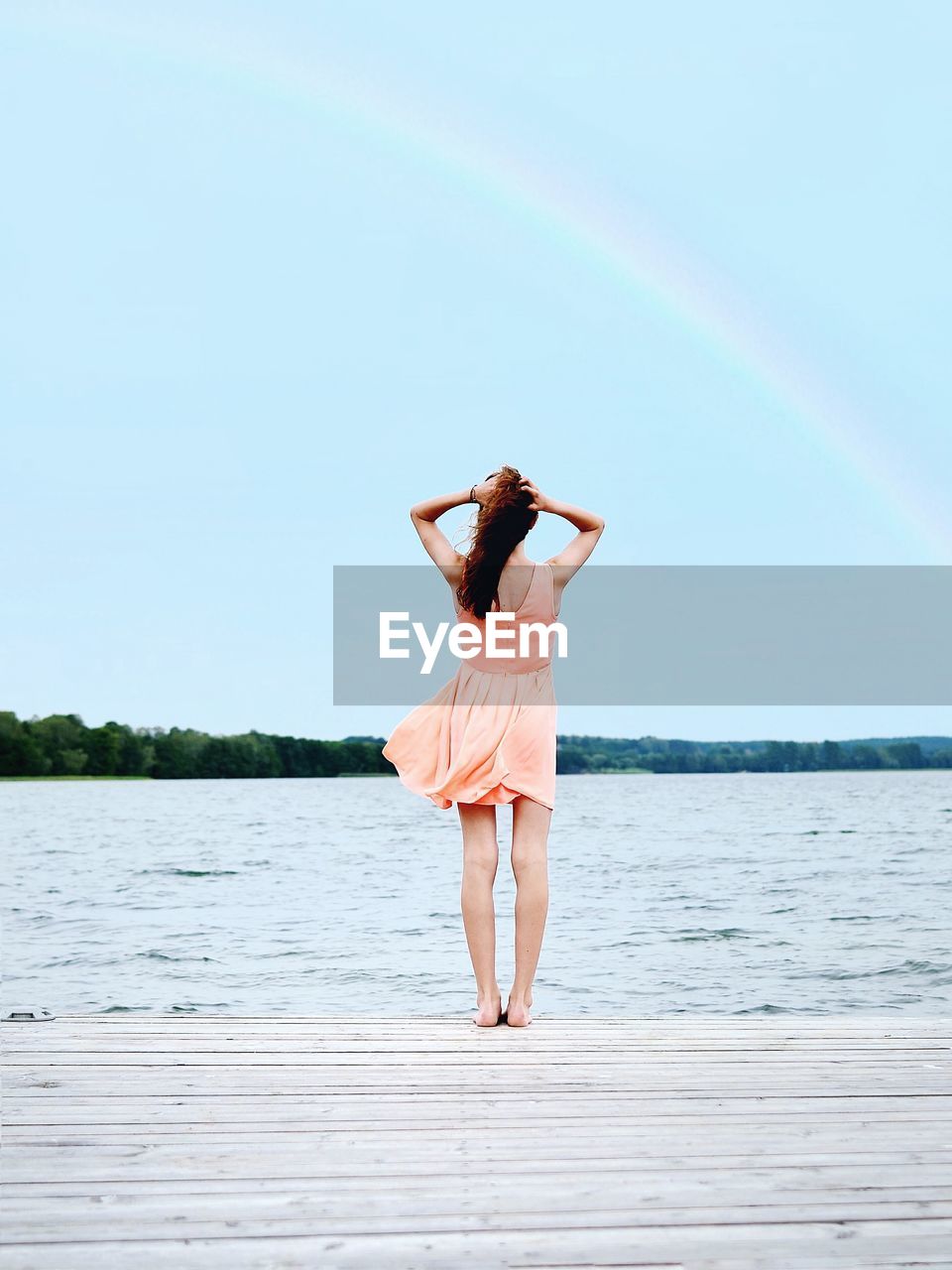Woman standing on pier by lake