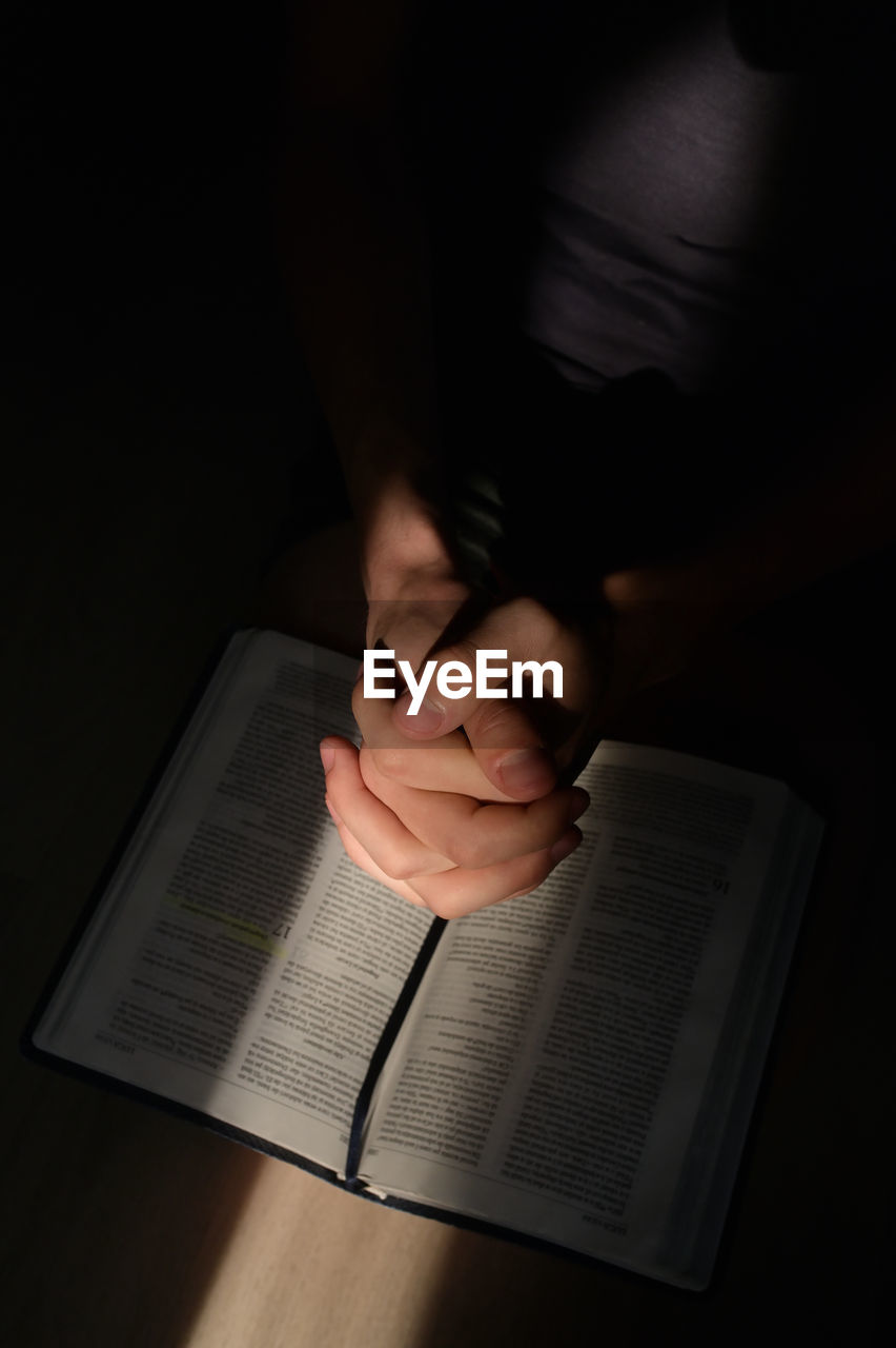 High angle view of woman praying in darkroom