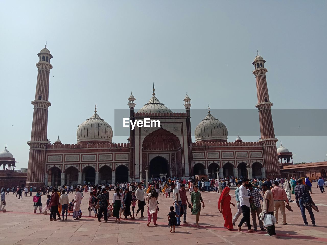 group of people in front of historic building against clear sky