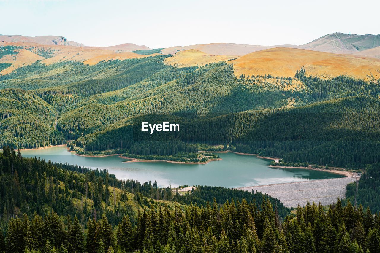 Scenic view of lake and mountains against sky during summer