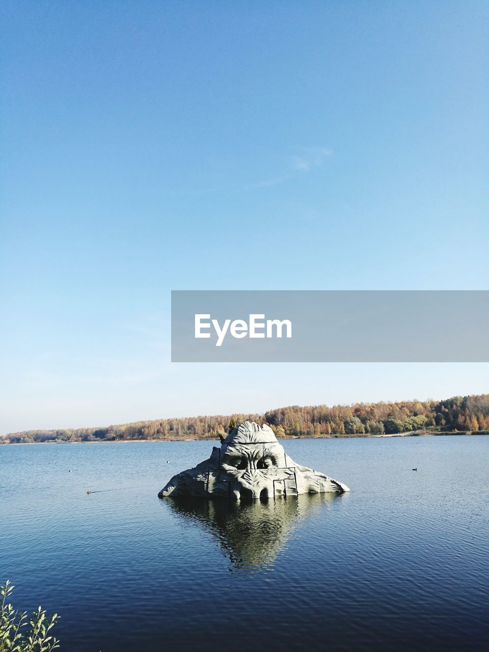 Scenic view of lake against clear blue sky