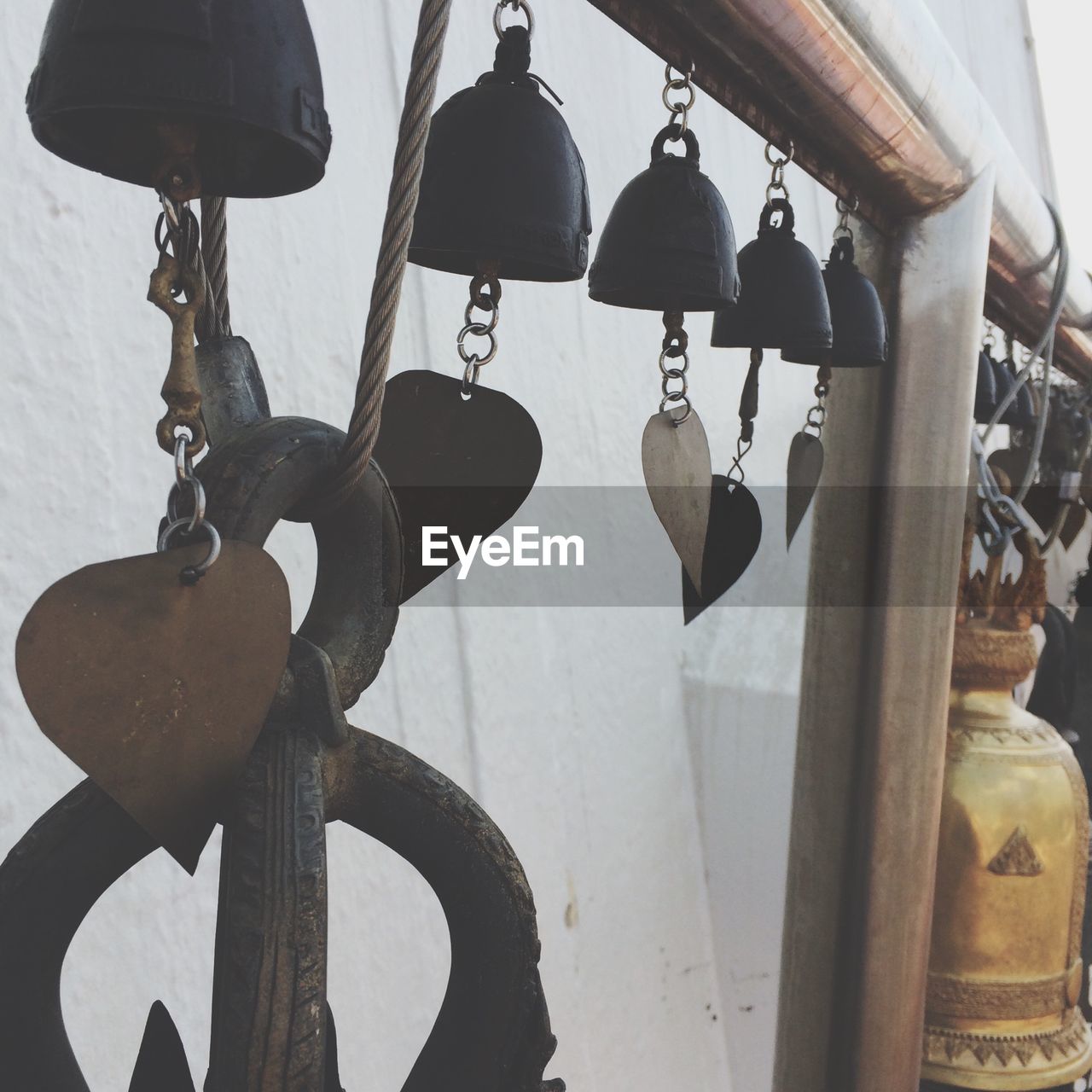 Close-up of bells hanging on railing outside temple