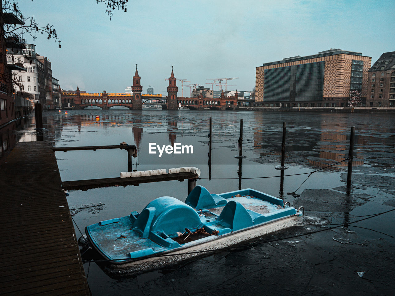 Boats moored in river against buildings in city