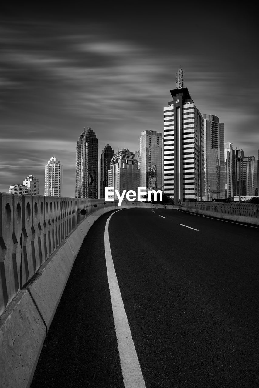 Road amidst buildings against sky in city