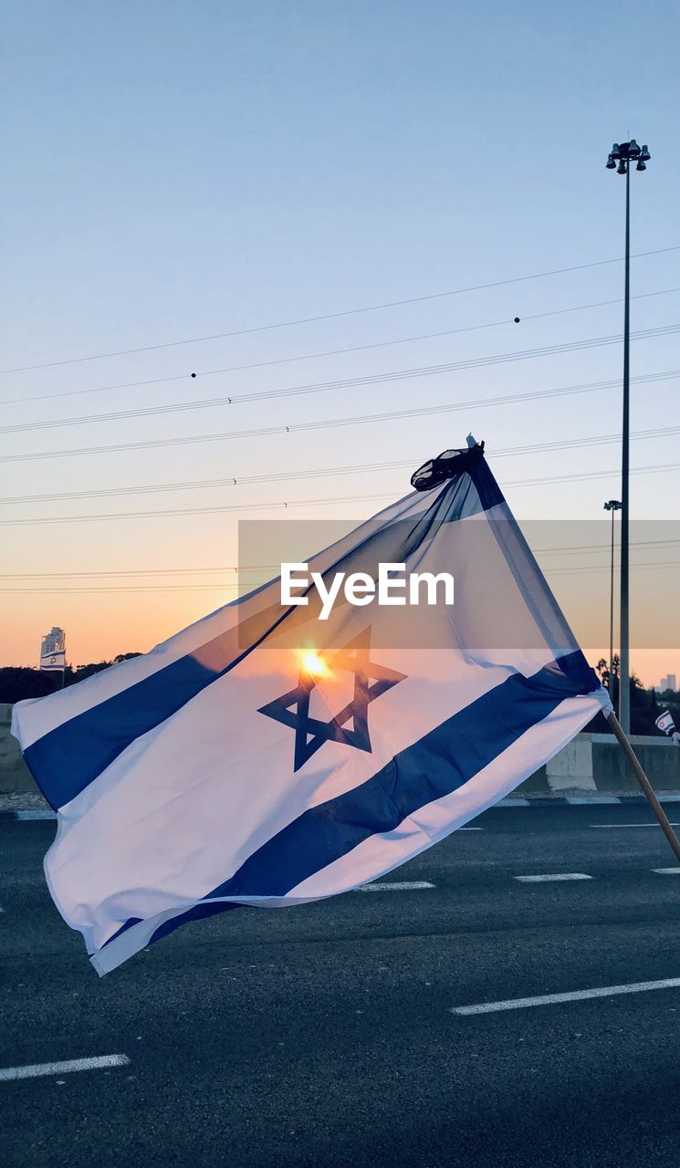 Low angle view of israel flag against sky during sunset