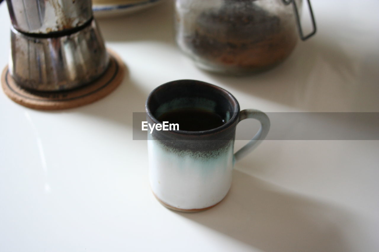 HIGH ANGLE VIEW OF COFFEE CUP AND SPOON ON TABLE