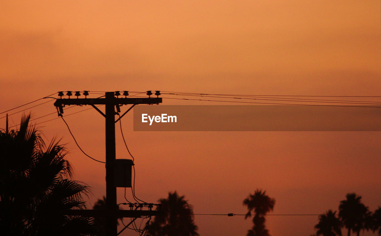 SILHOUETTE OF ELECTRICITY PYLON AGAINST SKY DURING SUNSET